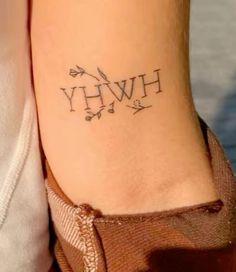 a woman's foot with the word hwh tattooed on her left ankle