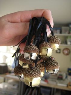 a hand holding several small bells in it's palm, with other decorations around them