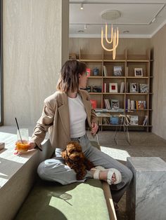 a woman sitting on top of a bed next to a stuffed animal