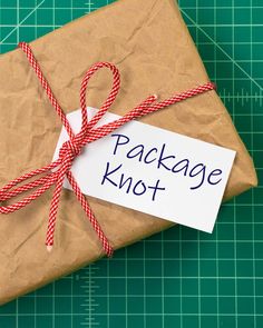 a package wrapped in brown paper with a red and white string tied around the top