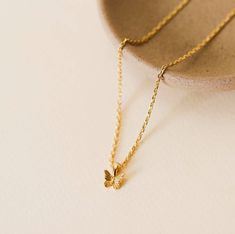 A gold mini butterfly charm set on a diamond cut chain. Tarnish Free - Long lasting protective coating safeguarding your jewelry from sweat, water, and more. 5x more gold that standard 18k gold plating over brass Hypoallergenic Lead Free Adjustable 16in to 18in Dainty Gold Butterfly Jewelry, Delicate Gold Butterfly Necklace With Adjustable Chain, Everyday Hypoallergenic Yellow Gold Charm Necklaces, Gold Butterfly Charm Necklace For Everyday, Gold Butterfly Necklace For Everyday Wear, Everyday Gold Necklace With Butterfly Charm, Dainty Gold Butterfly Necklace With Adjustable Chain, Dainty Gold Butterfly Charm Necklace, Dainty Gold Butterfly Necklace With Delicate Chain