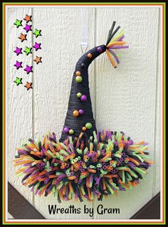 a witch hat made out of yarn with stars on the wall behind it and text overlay that reads, wreaths by gramm