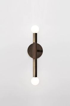 a wall light with two lights on the side and one in the middle, against a white background