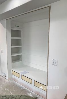 an empty room with white walls and shelves in the process of remodeling