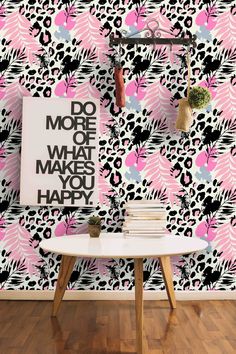 a pink and black wallpaper with an animal print pattern on it, next to a white table