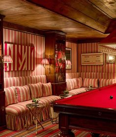 a pool table in a room with striped walls