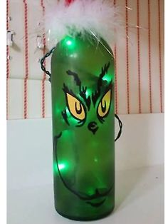 a green glass bottle with an angry grin face on it's lid and lights in the shape of eyes