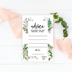 a floral wedding advice card with greenery and pink flowers on the front, next to a plant