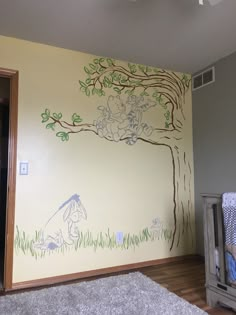 a child's room with a tree painted on the wall