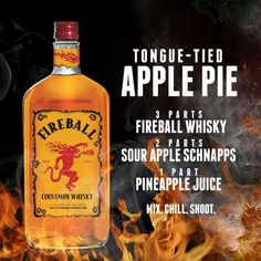 a bottle of fireball whiskey sitting on top of a table next to some flames