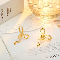 Who says everyday can't be charming? Gold Bow Earrings bring the coquette aesthetic with their classic ribbon design, meticulously designed with gleaming gold. Lightweight and comfortable, these high-quality earrings boast a smooth, shiny finish and long-lasting color. Effortlessly versatile, they pair perfectly with any outfit. Get ready to transform your everyday look from ordinary to oh-so-cute! DETAILS Plating: 18k Gold  Materials: 18k Gold on 925  Sterling Silver Size: 1.18"*0.98"(3.0cm*2.5 Gold Dainty Bow Earrings, Gold Dainty Earrings With Bow, Dainty Gold Earrings With Bow, Dainty Gold Bow Earrings, Gold Wedding Jewelry With Butterfly Knot Detail, Chic Gold Earrings With Decorative Bow, Gold Earrings With Decorative Bow For Formal Occasions, Gold Ribbon Earrings For Party, Formal Gold Earrings With Decorative Bow