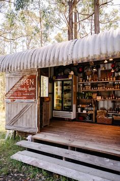 the outside of a small store with lots of bottles on it's display shelves