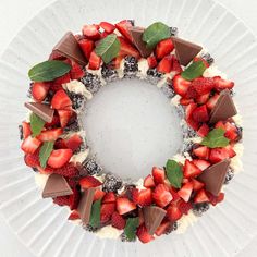 a white plate topped with a cake covered in chocolate, strawberries and mint leaves