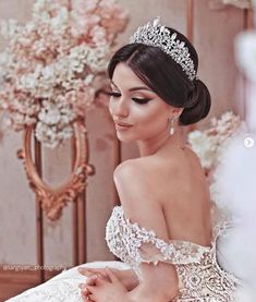 a woman wearing a tiara and sitting on a bed with flowers in the background