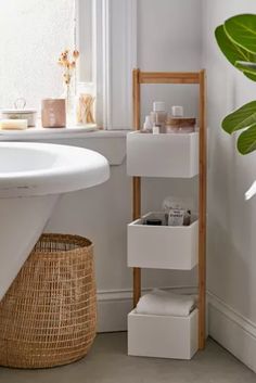 a white sink sitting next to a wooden shelf filled with containers and boxes on top of it