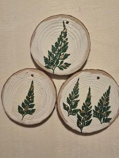 three pieces of wood with green leaves painted on them