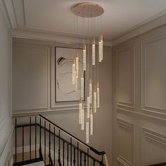 a chandelier hanging from the side of a stair case