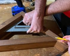 two people are working on woodworking in the process of making a frame for a mirror