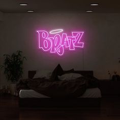 a bed in a room with a neon sign above it that says braz on the wall