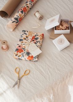 wrapping supplies are laid out on a table with scissors, tape and other crafting items