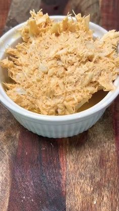 a white bowl filled with food on top of a wooden table