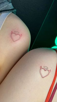 two small tattoos on the back of women's butts, one with an arrow and heart