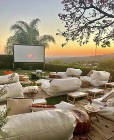 an outdoor movie is set up on the lawn with chairs and couches around it