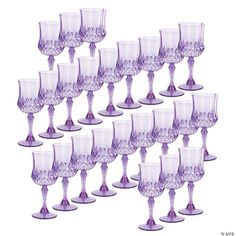 a bunch of wine glasses sitting next to each other on a white surface with purple rims