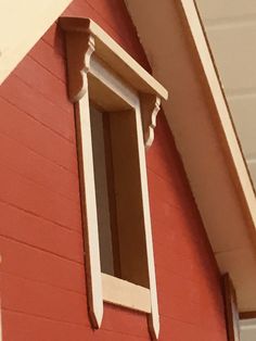 the corner of a red building with a white window