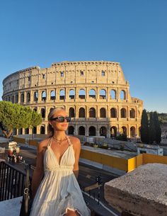 a woman standing in front of the colossion