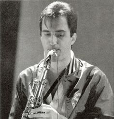 a man is playing the saxophone in black and white