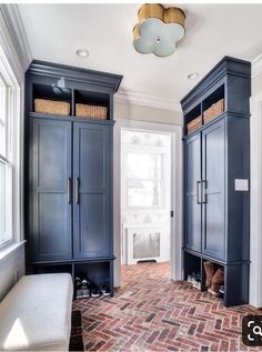 an instagram photo of a room with blue cabinets and brick flooring on the walls