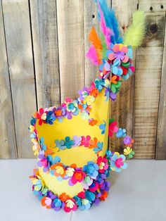 a yellow cake decorated with colorful flowers and feathers