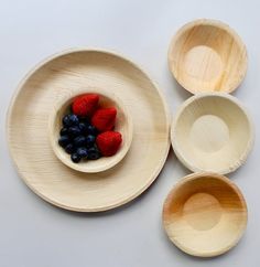 three bowls with strawberries and blueberries in them