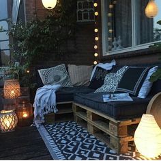 an outdoor living area with lights and pillows