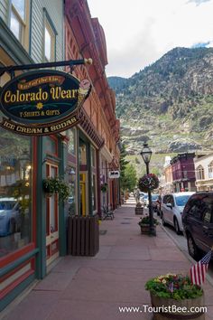 a street with cars parked on the side of it and a mountain in the background