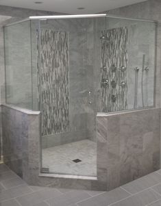 a walk in shower sitting inside of a bathroom next to a tiled floor and walls