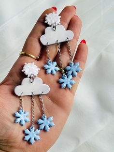 three snowflake charms are being held in someone's hand