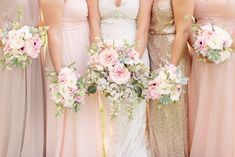 a group of women standing next to each other in dresses and holding bouquets with flowers