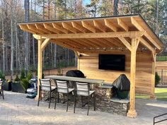 an outdoor kitchen with grill and seating area