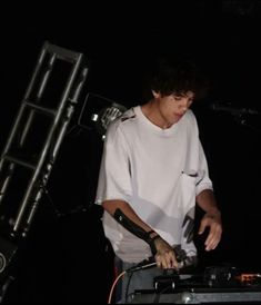 a young man standing next to a keyboard on top of a stage in front of a microphone