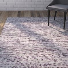 an area rug with a chair and brick wall in the background