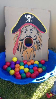 a cardboard box filled with candy balls and a pirate's hat on top of it