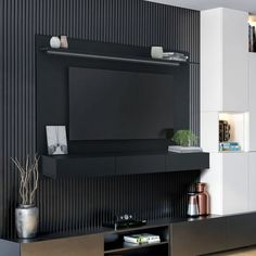 a modern living room with black and white decor on the wall, entertainment center and shelves