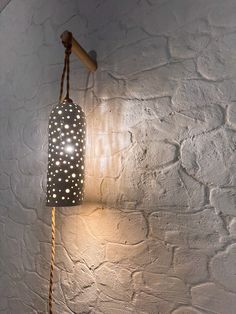 a light that is on the wall next to a lamp shade with lights all over it