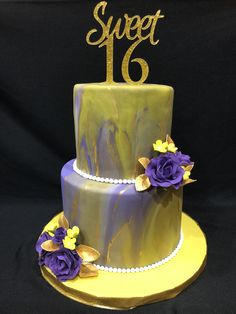 there is a purple and yellow cake with flowers on the top it says sweet 16