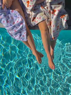 a child is floating in the pool with his feet on the edge of the water