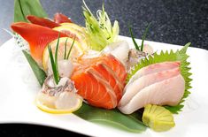 a white plate topped with lots of different types of sushi on top of it