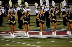 the cheerleaders are all dressed in black and yellow