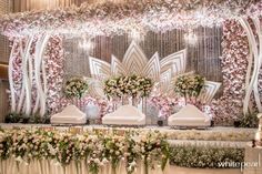 an elaborately decorated stage with flowers and greenery on it's sides for a wedding reception